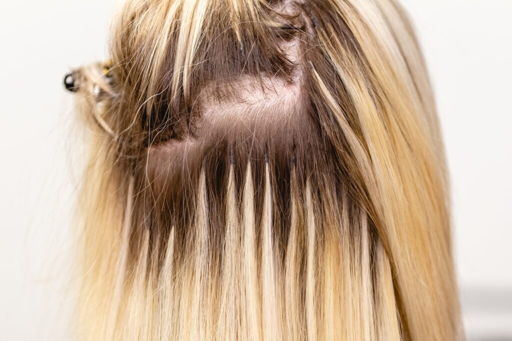 Strand-by-strand hair extensions fully installed and blended with natural hair.